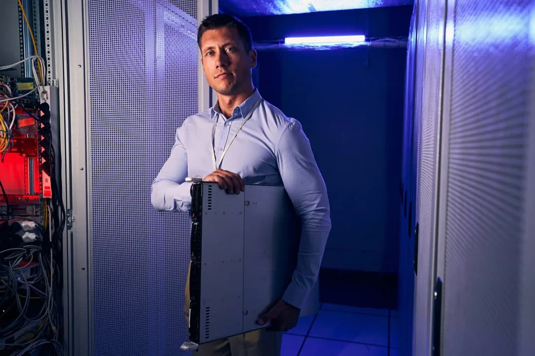 An RST Forum engineer carrying a server through the rack aisle